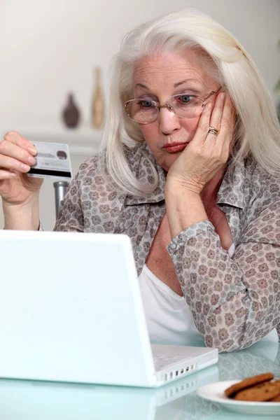 Ältere Dame verwirrt durch Aussicht auf Online-Einkauf — Stockfoto