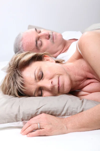 Äldre par sover i sängen — Stockfoto