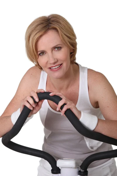 Portrait of a woman on exercise bike — Stock Photo, Image