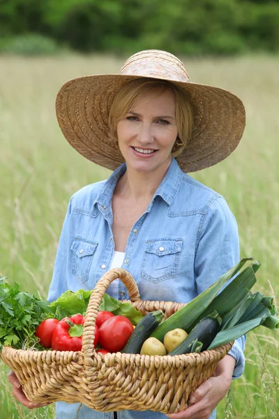 Frau stand mit Gemüsekorb auf Feld — Stockfoto