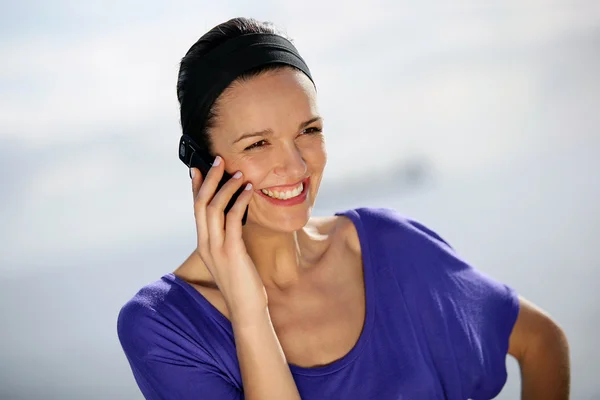 Lachende vrouw met behulp van een telefoon Stockfoto