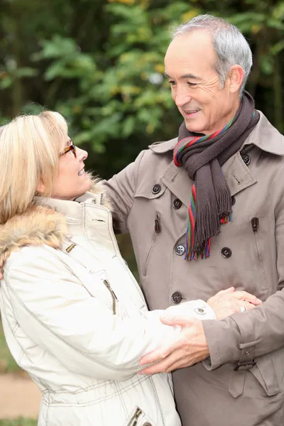 Casal mais velho abraçando em um passeio de inverno Imagens Royalty-Free