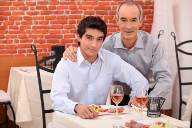 Two generations sitting in a restaurant clipart