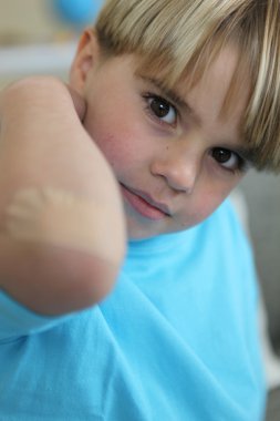 Little boy showing his bandage on elbow clipart