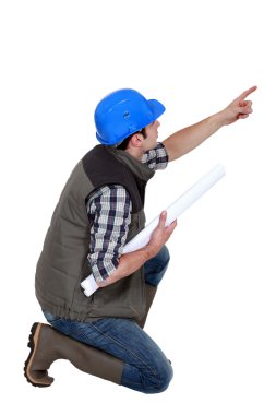 Architect pointing whilst crouched down clipart