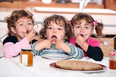 Little kids eating pancakes clipart