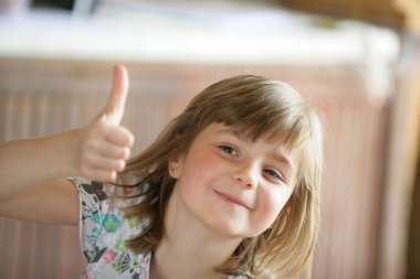 Young girl giving the thumb's up clipart