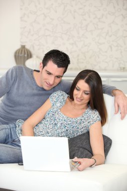 Couple on couch with computer clipart