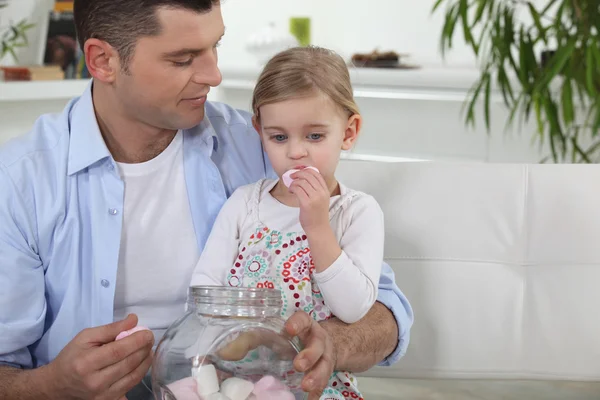 Otec a jeho dcera jíst marshmallows — Stock fotografie