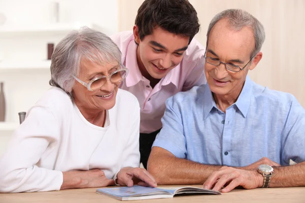 Par pensionärer med sina barnbarn hem — Stockfoto