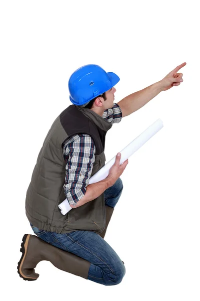 Architect pointing whilst crouched down — Stock Photo, Image