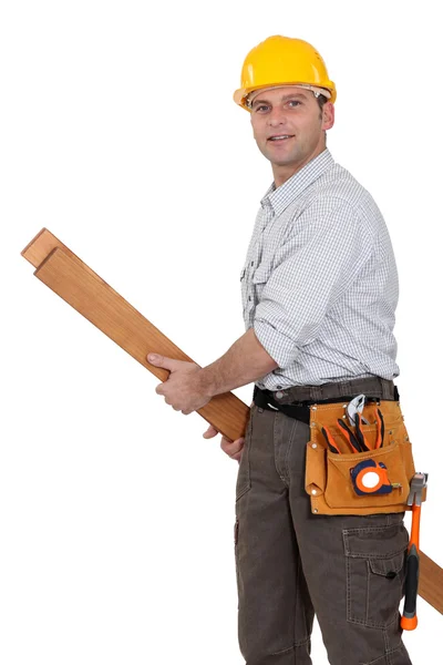 Tradesman carrying planks of wood — Stock Photo, Image