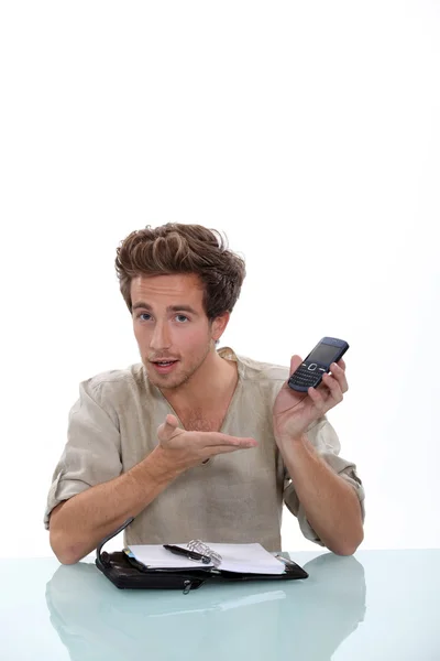 Молодий чоловік з особистим організатором і мобільним телефоном — стокове фото
