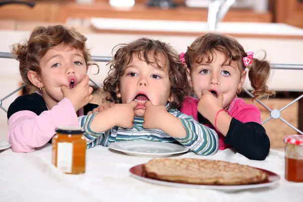 Little kids eating pancakes — Stock Photo, Image