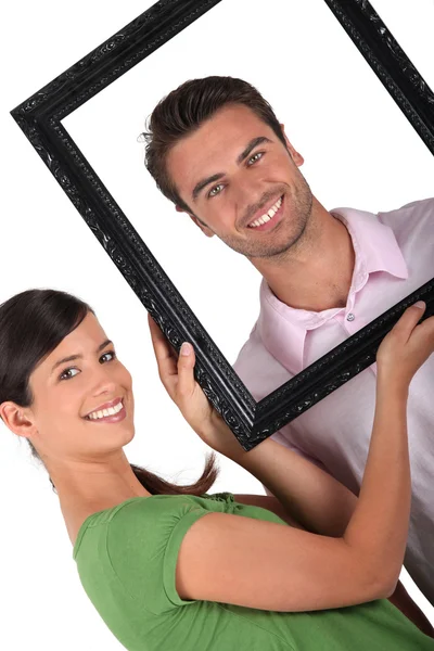 Couple with a picture frame — Stock Photo, Image