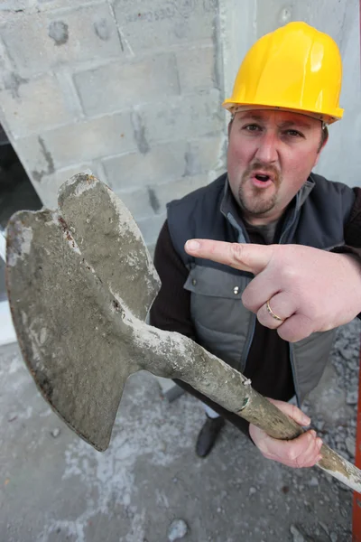 Tradesman pointing to a worn out spade — Stock Photo, Image