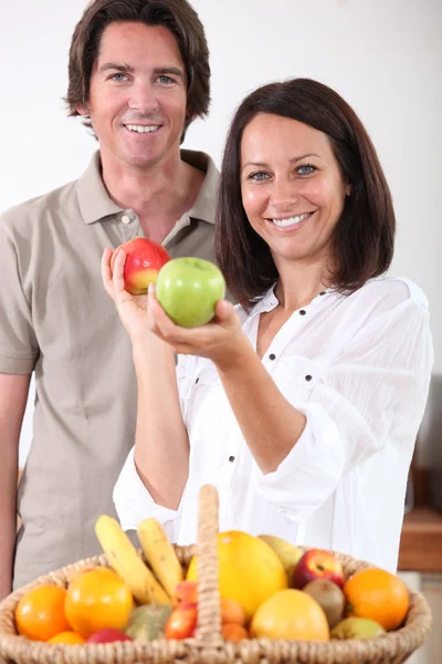 Man and woman with a basket of fresh fruit — Stock Photo, Image
