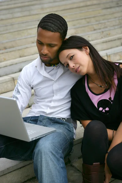Jeune couple sur quelques marches avec un ordinateur portable — Photo