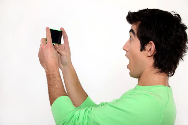 Zaskoczony człowiek ogląda swój telefon komórkowy — Zdjęcie stockowe