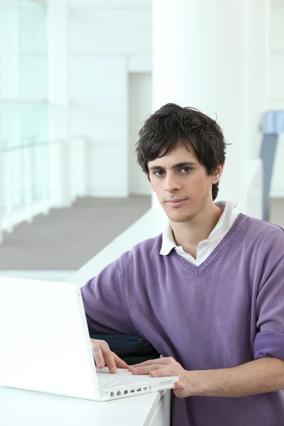 Νεαρός που χρησιμοποιεί τον υπολογιστή του στο πανεπιστήμιο — Φωτογραφία Αρχείου
