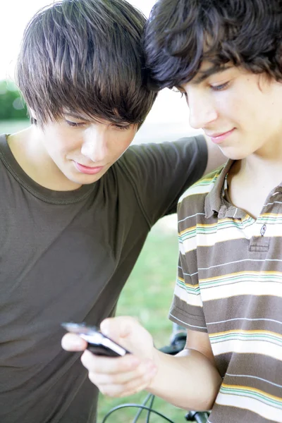 Два подростка читают текстовые сообщения — стоковое фото
