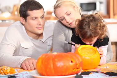 Family preparing pumpkins for Halloween clipart