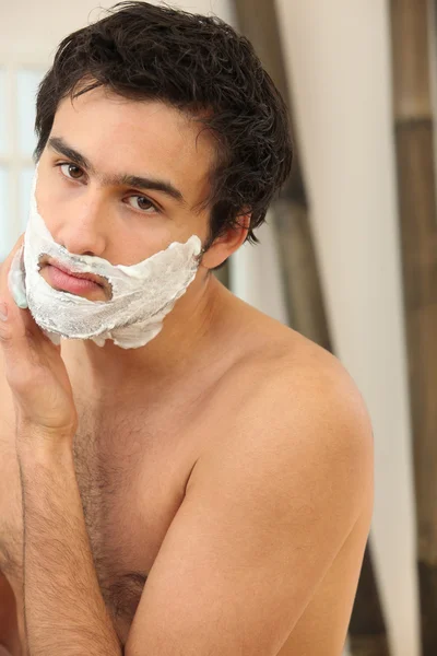 Мужчина бреется в ванной — стоковое фото