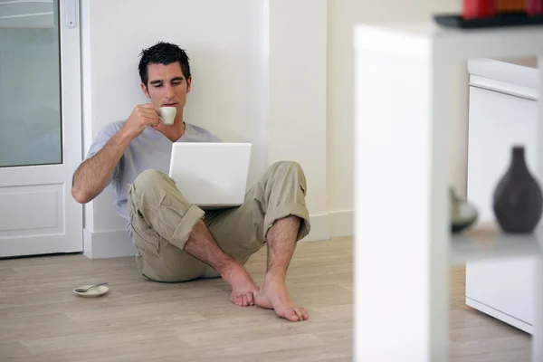 Ember ült a padlón, a hazai iszik kávé — Stock Fotó