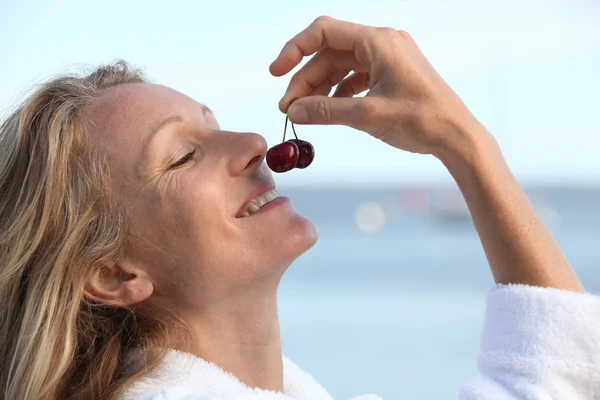 Woman smelling cherries — Stock Photo, Image