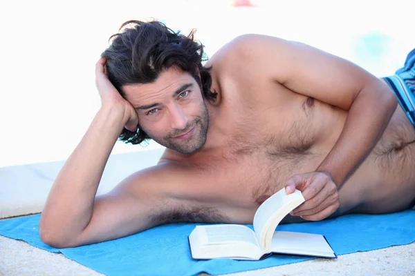 Чоловік читає на пляжі — стокове фото