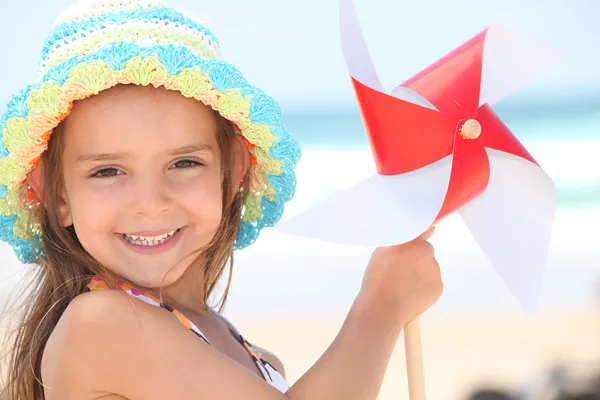 Kleines Mädchen spielt mit Wind-Spielzeug am Strand — Stockfoto