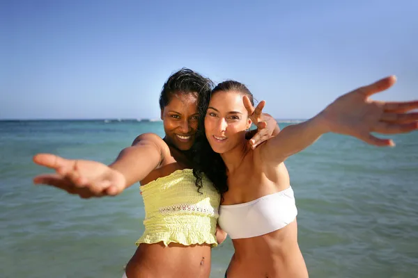 Kvinnliga vänner ber dig att gå med dem på stranden — Stockfoto