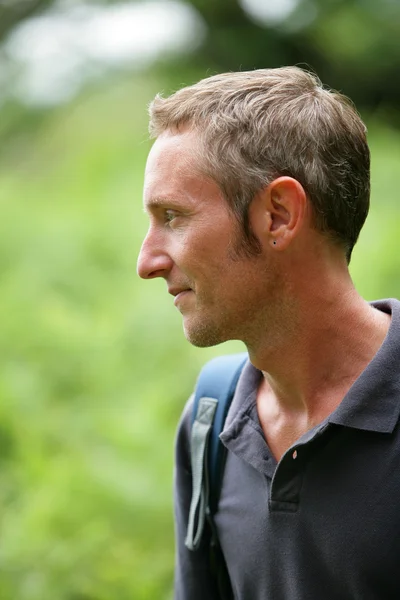 Mężczyzna spacerując po lesie, noszenie plecaka — Zdjęcie stockowe
