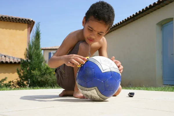 Liten pojke leker med boll — Stockfoto