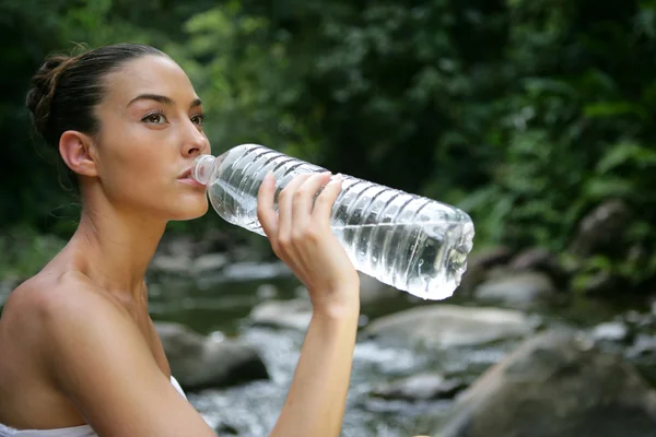 Жінка п'є з пляшки води — стокове фото