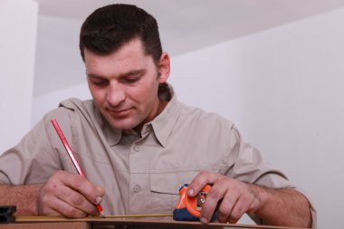 Tradesman marking a measurement with a pencil clipart