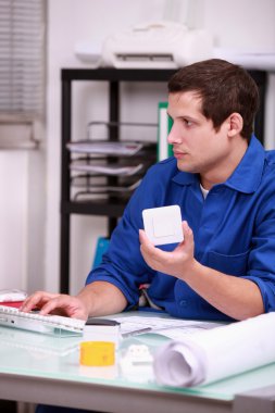 Warehouse worker ordering new parts on the Internet clipart