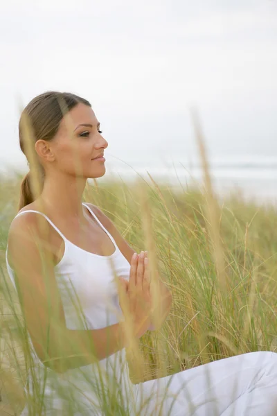 Frau macht Yoga am Strand — Stockfoto