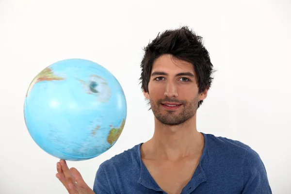 Man spinning a globe on his fingertips — Stock Photo, Image