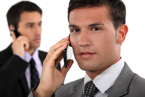 Uomini d'affari che parlano sui loro telefoni cellulari — Foto Stock