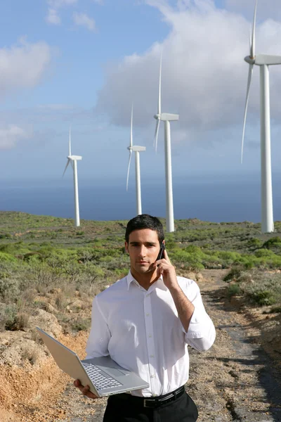 Человек с ноутбуком стоял на ветряной электростанции — стоковое фото