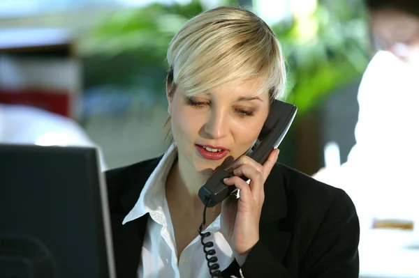 Sabit hat telefon kullanarak sarışın ofis çalışanı — Stok fotoğraf
