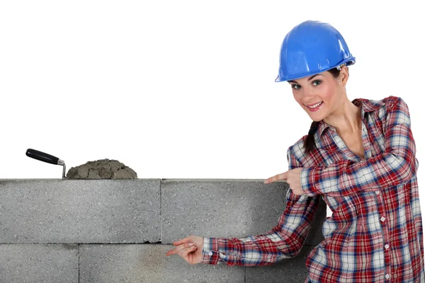 Un muratore femminile che mostra il suo lavoro . — Foto Stock