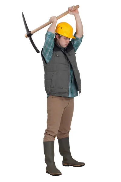Man using pickaxe, studio shot — Stock Photo, Image