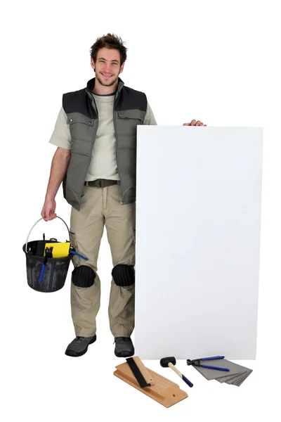 Handyman with a board left blank for your message — Stock Photo, Image