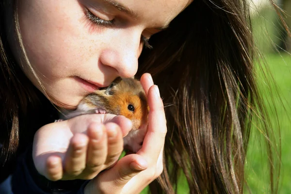Küçük kız onu evde beslenen hayvan hamster — Stok fotoğraf