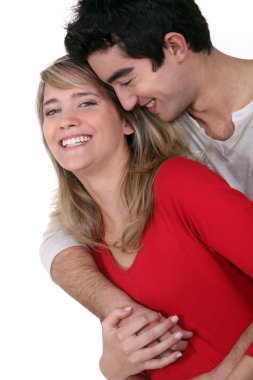 Young couple hugging in studio clipart