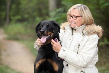 Woman taking her dog out for a walk clipart