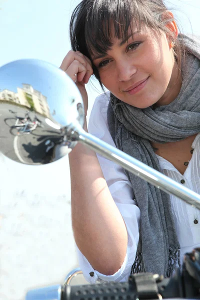 Mulher olhando para o espelho da asa de seu ciclomotor — Fotografia de Stock