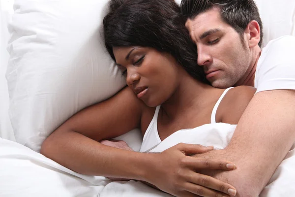 Husband and wife snuggling in bed — Stockfoto